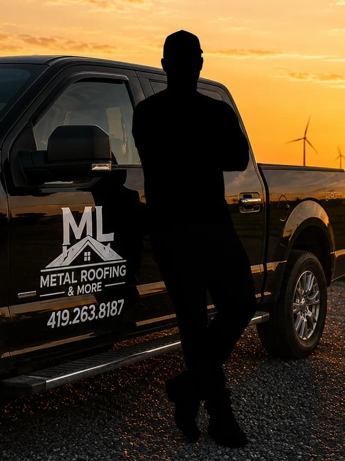 Matt Schwartz leaning against his ML Metal Roofing truck at golden hour, wind turbines on the horizon